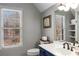 Well-lit bathroom with classic fixtures, a large window, and a stylish vanity at 9465 Mistwater Close, Roswell, GA 30076