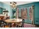 Elegant dining room featuring a wood table, four chairs, chandelier, and natural light from surrounding windows at 9465 Mistwater Close, Roswell, GA 30076