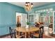 Charming dining room with teal walls, chandelier, and view into adjoining living space at 9465 Mistwater Close, Roswell, GA 30076