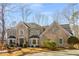 Elegant two-story brick home showcases a landscaped front yard and traditional architecture with green shutters at 9465 Mistwater Close, Roswell, GA 30076