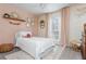 This bedroom has a pink wall, white bed, and wicker decor at 1323 Weatherstone Ne Way, Atlanta, GA 30324