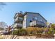 A gray apartment building with fenced patios is surrounded by greenery at 1323 Weatherstone Ne Way, Atlanta, GA 30324