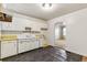 Modest kitchen with white cabinets, yellow counters, and dark wood-look flooring at 162 Fairburn Sw Rd, Atlanta, GA 30331