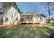 A pleasant backyard featuring a screened porch and deck adjoined to the home, with the shadow of trees cast on the lawn at 305 Deep Step Rd, Covington, GA 30014