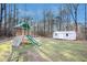 Spacious backyard features playground set and storage building, surrounded by many tall trees at 305 Deep Step Rd, Covington, GA 30014