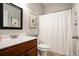 Bathroom featuring a vanity, toilet, shower with curtain, and decorative art at 305 Deep Step Rd, Covington, GA 30014