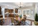 Bright dining room featuring a wood table and chair set, opening into a kitchen with stainless appliances and wood cabinets at 305 Deep Step Rd, Covington, GA 30014