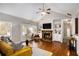 Bright living room with a stone fireplace, hardwood floors, and built-in shelving at 305 Deep Step Rd, Covington, GA 30014