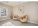 Cozy seating area with neutral paint, carpet, comfortable chairs, and a large window for natural lighting at 305 Deep Step Rd, Covington, GA 30014