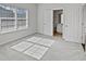 Bright bedroom with large window, neutral carpet, and an ensuite bathroom through an open door at 5692 Greensage Dr, Atlanta, GA 30349