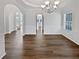 Open dining room with arched doorways, dark floors, and white walls at 5692 Greensage Dr, Atlanta, GA 30349