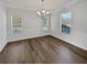 Dining room features two large windows, chandelier, white walls, and dark floors at 5692 Greensage Dr, Atlanta, GA 30349