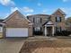 Charming two-story brick home with attached two car garage, manicured front yard, and inviting entrance at 5692 Greensage Dr, Atlanta, GA 30349