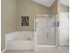 A full bathroom features a soaking tub and stand up shower with glass doors at 1090 Fountain Head Ln, Lawrenceville, GA 30043