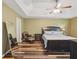 Serene main bedroom with trey ceiling, neutral walls, hardwood flooring, and a comfortable seating area at 1090 Fountain Head Ln, Lawrenceville, GA 30043