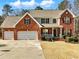 Charming two-story brick home with a three-car garage and manicured front yard at 1090 Fountain Head Ln, Lawrenceville, GA 30043