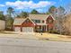 Inviting two-story brick home with a manicured lawn, a two-car garage, and a welcoming front porch at 1090 Fountain Head Ln, Lawrenceville, GA 30043