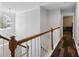 Upstairs hallway with crown molding, hardwood floors, a window and entry to a bedroom at 1090 Fountain Head Ln, Lawrenceville, GA 30043