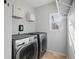 Practical laundry room with modern washer and dryer, shelving, and natural light from a window at 1090 Fountain Head Ln, Lawrenceville, GA 30043