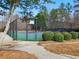 Well-maintained, fenced-in tennis court with shade trees provides an opportunity for exercise and recreation at 1090 Fountain Head Ln, Lawrenceville, GA 30043