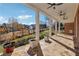 Inviting covered patio with stone floors and ceiling fans overlooking a well-manicured yard at 2850 Brandy Ln, Cumming, GA 30041
