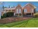 Charming brick home with dormers and covered porch, set on a beautifully landscaped lawn with retaining wall at 2850 Brandy Ln, Cumming, GA 30041