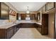 Spacious kitchen with dark wood cabinets, tile floors, and a double sink overlooking an awning covered window at 2850 Brandy Ln, Cumming, GA 30041