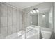 Bright bathroom features a shower-tub combo with tiled walls, vanity, and a large mirror at 10152 Griffin Sw Ln, Covington, GA 30014