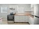 An updated kitchen with stainless steel appliances, white cabinets and butcher block countertops at 10152 Griffin Sw Ln, Covington, GA 30014