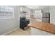 Updated kitchen with stainless steel appliances, white cabinetry, and butcher block countertops at 10152 Griffin Sw Ln, Covington, GA 30014