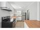 Modern kitchen features white cabinets, butcher block countertops, stainless steel appliances, and tile backsplash at 10152 Griffin Sw Ln, Covington, GA 30014