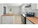 Updated kitchen features white cabinets, stainless appliances, and butcher block countertops at 10152 Griffin Sw Ln, Covington, GA 30014