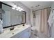 Bright bathroom featuring a double sink vanity with modern fixtures, and a shower with a neutral-toned curtain at 210 Wrights Mill Way, Canton, GA 30115