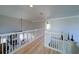 Open hallway with white railing, wood floors, and natural light, connecting different areas of the home at 210 Wrights Mill Way, Canton, GA 30115