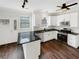 Well-lit kitchen features stainless appliances, white cabinets, granite countertops, and hardwood flooring at 2180 Sugarbirch Dr, Grayson, GA 30044