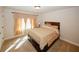 Well-lit bedroom with a large bed, neutral colors, and a view of the yard at 4594 Marching Ln, Fairburn, GA 30213