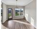 Bright dining area with wood floors, large windows overlooking the backyard, and modern light fixture at 507 N Gwinnett St, Buford, GA 30518