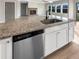 Close up of a kitchen island featuring granite countertops, stainless steel appliances and white cabinets at 507 N Gwinnett St, Buford, GA 30518