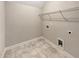 Well-lit laundry room features tile flooring, wire shelving, and essential hookups at 507 N Gwinnett St, Buford, GA 30518