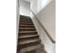 Carpeted staircase with wooden handrail leading to the next level of the home at 507 N Gwinnett St, Buford, GA 30518