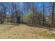 Large backyard with a mix of grass and natural growth, offering a private outdoor space at 11139 Silver Aspen Ct, Hampton, GA 30228