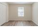 A bright bedroom with hardwood floors, window and a closet at 11139 Silver Aspen Ct, Hampton, GA 30228