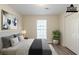 A staged bedroom with a bed, window, and hardwood floors at 11139 Silver Aspen Ct, Hampton, GA 30228