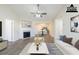 Bright, staged living room boasts hardwood floors, fireplace, ceiling fan, and an open floor plan at 11139 Silver Aspen Ct, Hampton, GA 30228