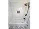 Shower with white subway tile, black fixtures, and patterned tile floor at 2308 Baywood Se Dr, Atlanta, GA 30315
