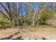 View of the backyard with mature trees, and a chain-link fence at 4051 Ester Sw Dr, Atlanta, GA 30331