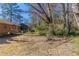 Landscaped backyard with a lawn, mature trees, and a screened-in porch at 4051 Ester Sw Dr, Atlanta, GA 30331