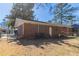 View of the backyard featuring a brick house, chain-link fence, and mature trees at 4051 Ester Sw Dr, Atlanta, GA 30331