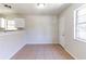 Bright dining area with tile floors adjacent to kitchen with window views, a doorway, and fresh white paint at 4051 Ester Sw Dr, Atlanta, GA 30331