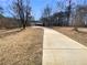 Long driveway leading to a charming house with a three-car garage surrounded by a natural landscape at 8014 Bells Ferry Rd, Canton, GA 30114